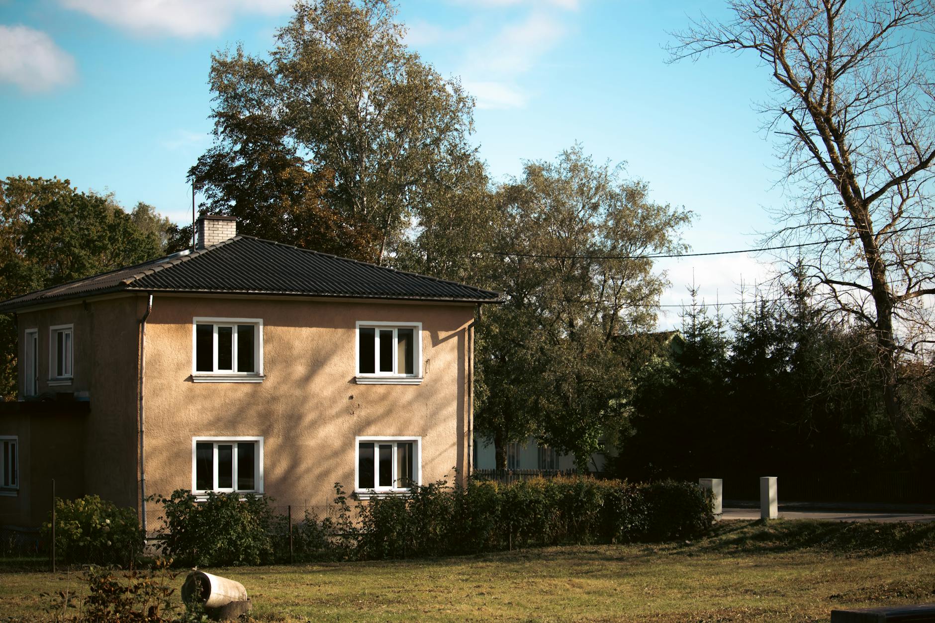 A picturesque view of a traditional house surrounded by autumn foliage in Tartu, Estonia.