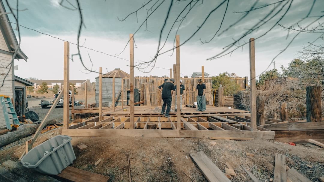 Construction workers building a wooden structure outdoors