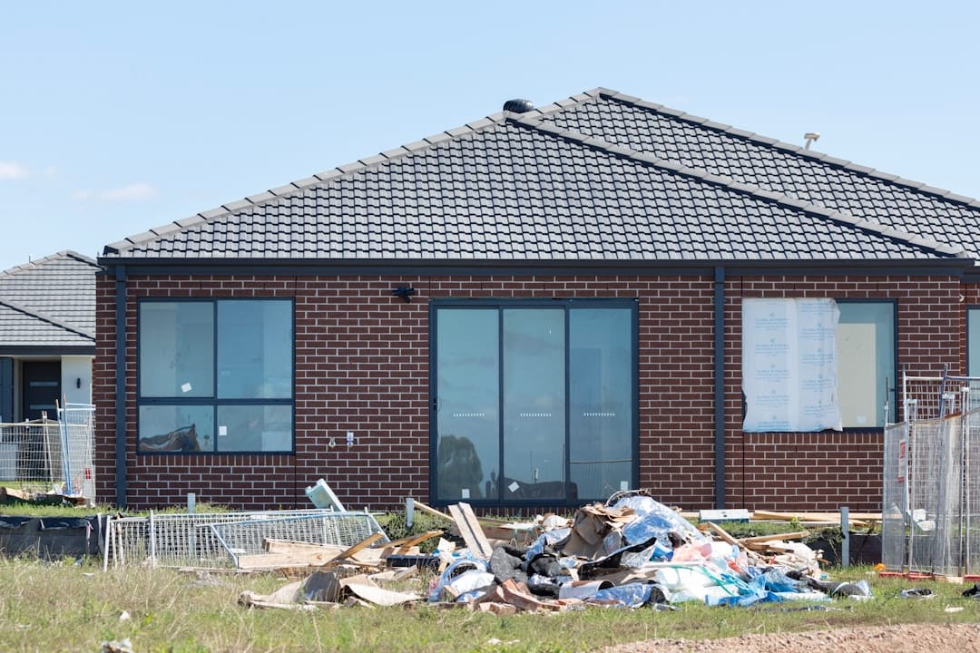 Construction debris piled in front of a brick house